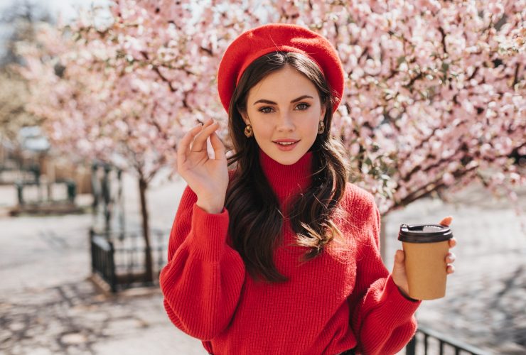 lady-walks-along-avenue-with-sakura-drinks-coffee
